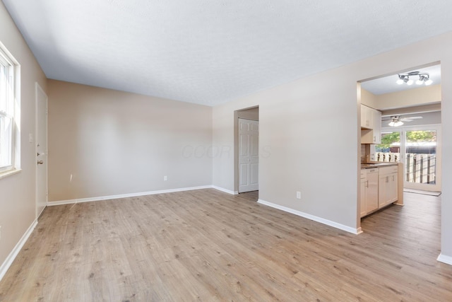 spare room with ceiling fan, a textured ceiling, and light hardwood / wood-style floors