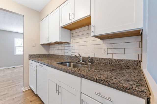 kitchen featuring dishwasher, white cabinets, and dark stone counters