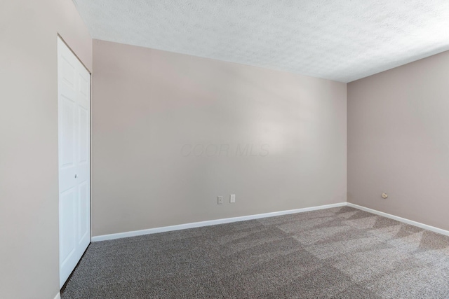 unfurnished room featuring carpet floors and a textured ceiling