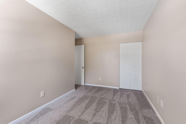 unfurnished room with carpet floors and a textured ceiling