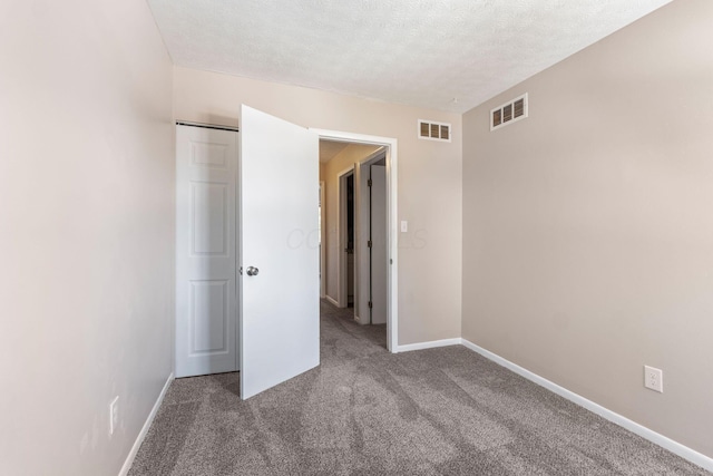 unfurnished bedroom featuring carpet flooring, a textured ceiling, and a closet