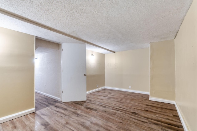 unfurnished room featuring wood-type flooring and a textured ceiling