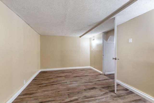 basement with hardwood / wood-style floors and a textured ceiling