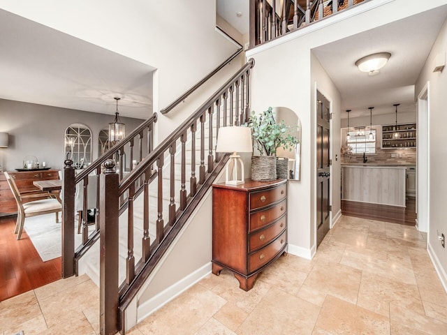 staircase with a chandelier