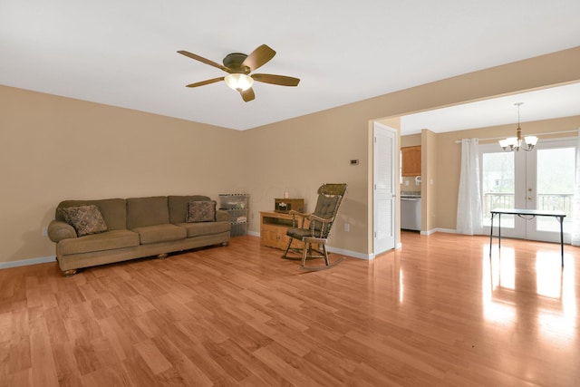 living room featuring ceiling fan with notable chandelier, light hardwood / wood-style floors, and french doors