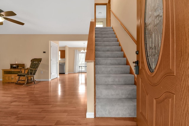 interior space featuring hardwood / wood-style flooring and ceiling fan with notable chandelier