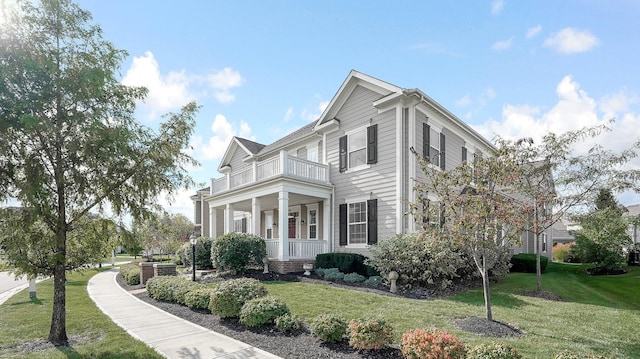 view of home's exterior featuring cooling unit, a balcony, a yard, and a porch