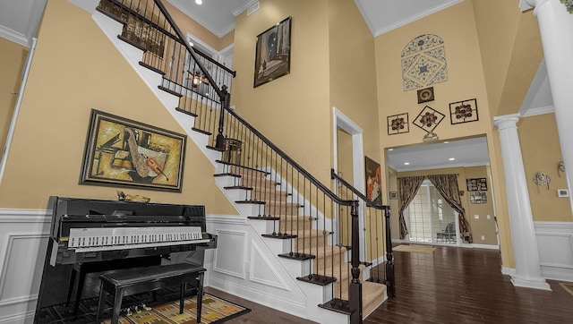 entryway featuring decorative columns, ornamental molding, and wood-type flooring