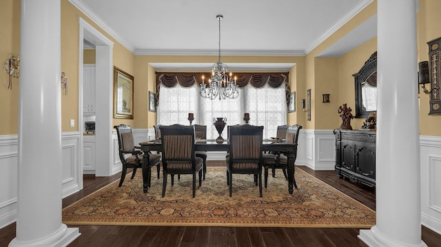 dining area with decorative columns, dark hardwood / wood-style flooring, ornamental molding, and an inviting chandelier