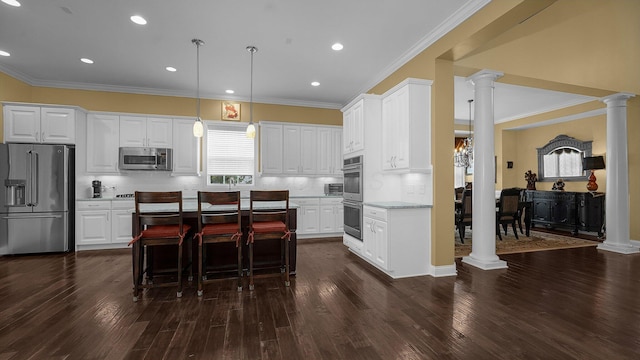 kitchen featuring dark hardwood / wood-style floors, pendant lighting, stainless steel appliances, decorative columns, and white cabinets