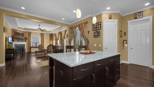 kitchen featuring dark hardwood / wood-style flooring, hanging light fixtures, ornamental molding, and a center island