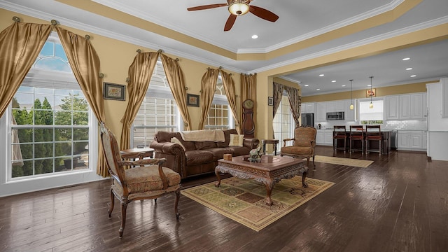 sitting room with plenty of natural light, ornamental molding, dark hardwood / wood-style floors, and ceiling fan