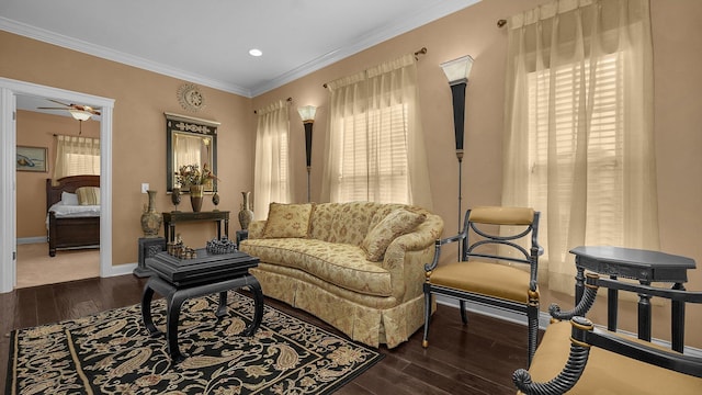 sitting room featuring dark wood-type flooring, ceiling fan, and ornamental molding