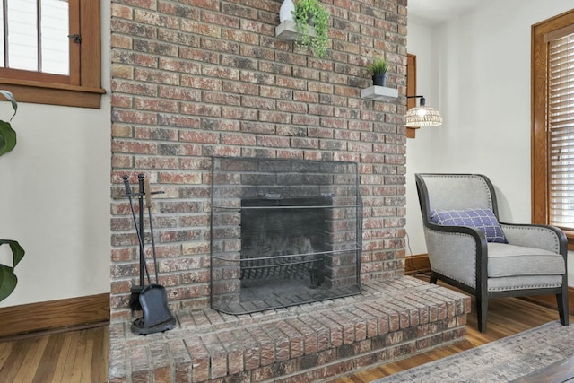 living room with wood-type flooring, a healthy amount of sunlight, and a fireplace