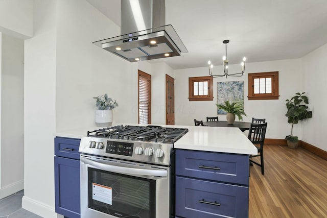 kitchen with blue cabinetry, dark hardwood / wood-style floors, island range hood, and stainless steel range with gas stovetop