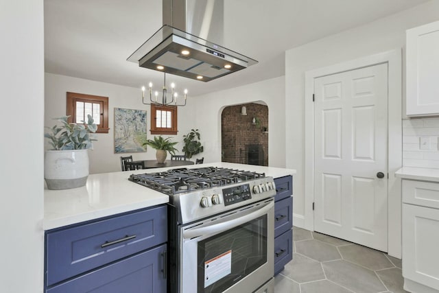 kitchen featuring blue cabinetry, white cabinetry, tasteful backsplash, island range hood, and gas stove