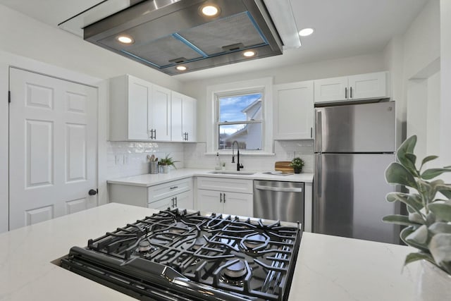 kitchen featuring sink, backsplash, range hood, stainless steel appliances, and white cabinets