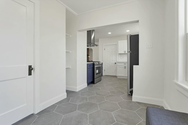 kitchen with light tile patterned floors, appliances with stainless steel finishes, white cabinets, wall chimney range hood, and backsplash