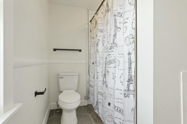 bathroom featuring tile patterned floors, toilet, and walk in shower