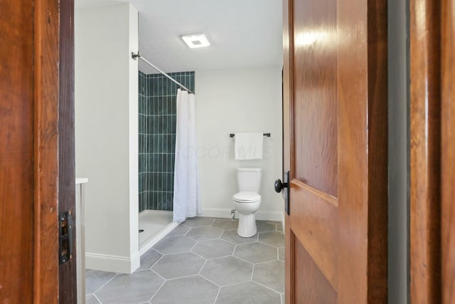 bathroom with tile patterned flooring, curtained shower, and toilet