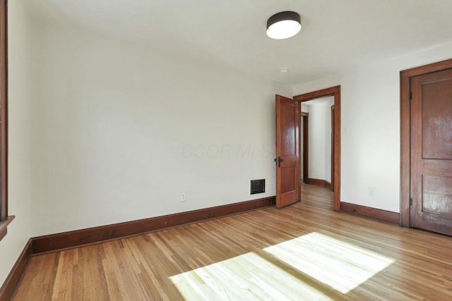 unfurnished room with light wood-type flooring