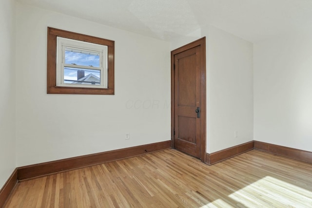 spare room with light hardwood / wood-style floors and a textured ceiling