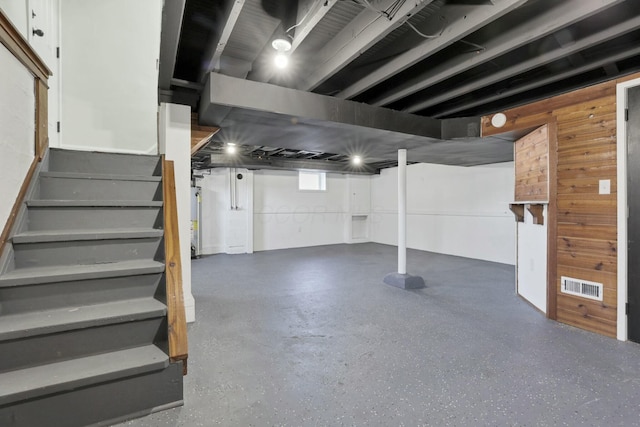 basement with wooden walls and gas water heater