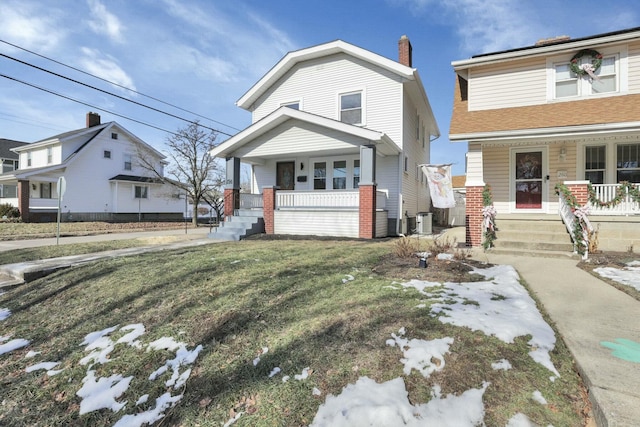 view of front of house with a porch, central AC unit, and a front lawn