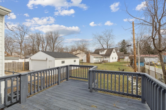 wooden terrace with a garage, a yard, and an outbuilding