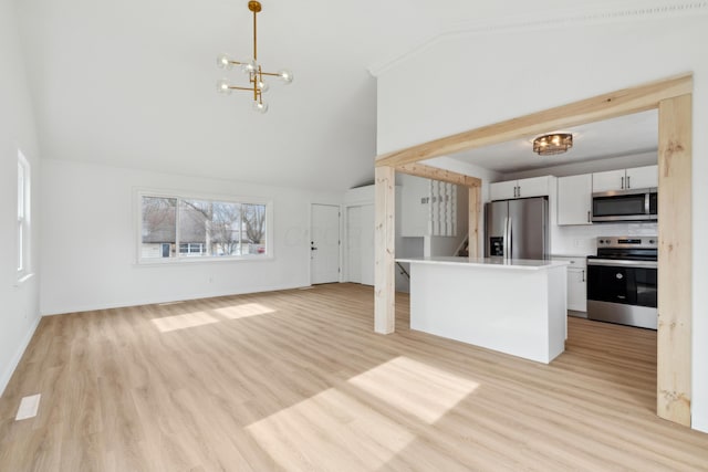 kitchen with appliances with stainless steel finishes, a notable chandelier, white cabinets, decorative light fixtures, and light wood-type flooring