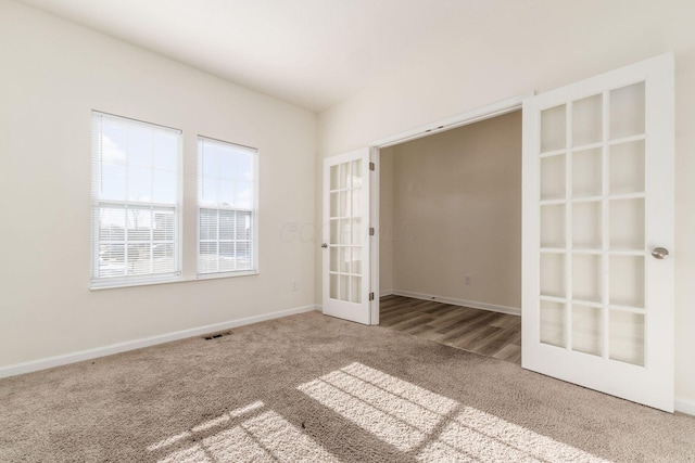 unfurnished room featuring carpet floors and french doors