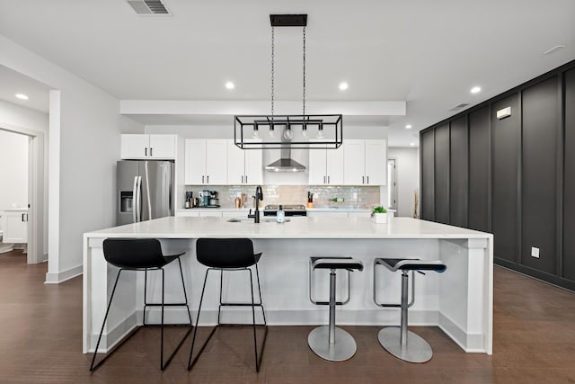 kitchen featuring white cabinetry, stainless steel fridge with ice dispenser, and a large island with sink