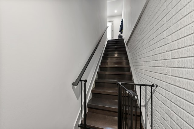 stairs featuring brick wall