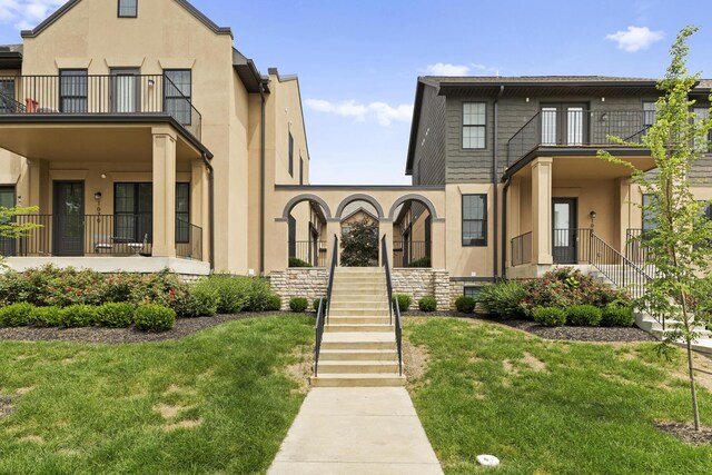 1078 Bryden Rd Unit 6, Columbus, OH 43205 - view of front of property featuring a balcony, stucco siding, stairway, and a front lawn