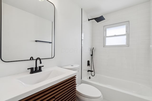 full bathroom featuring vanity, tiled shower / bath, and toilet