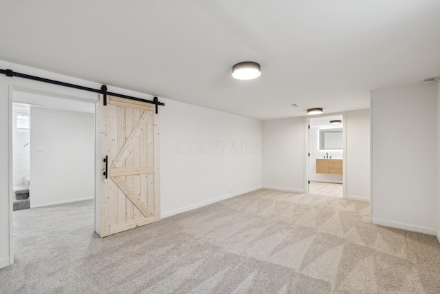 basement with a barn door and light colored carpet