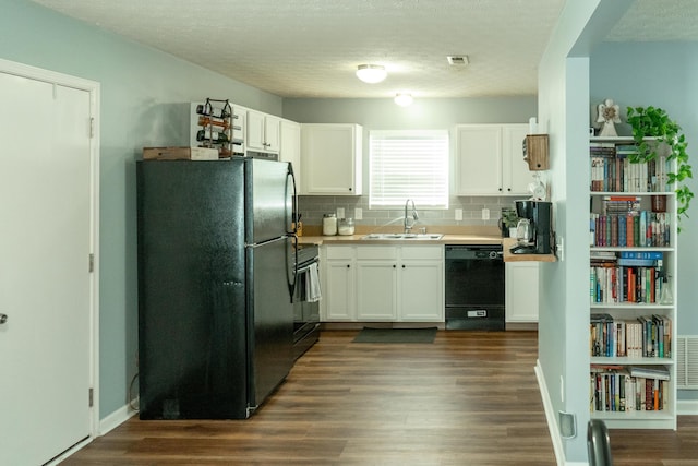 kitchen with a sink, white cabinets, light countertops, black appliances, and dark wood finished floors