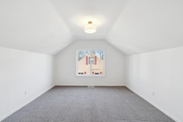 bonus room with lofted ceiling and carpet flooring