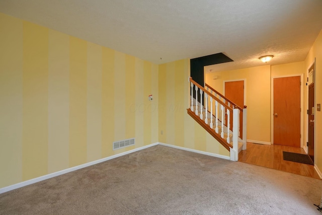 carpeted spare room with a textured ceiling