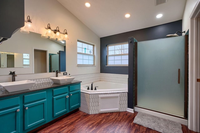 bathroom with vanity, separate shower and tub, vaulted ceiling, and hardwood / wood-style floors