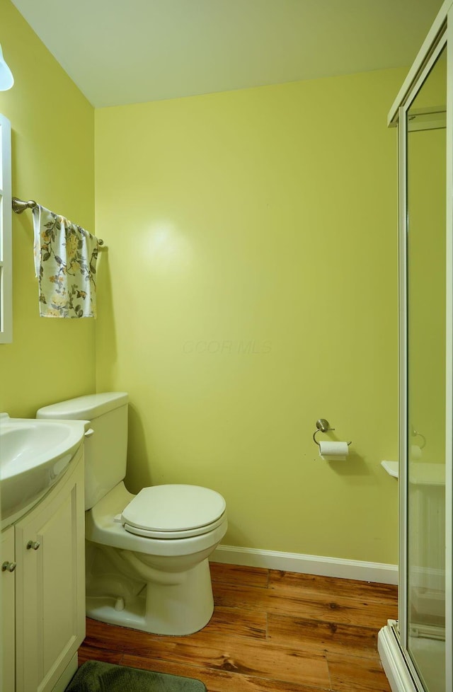 bathroom featuring vanity, toilet, an enclosed shower, and hardwood / wood-style floors