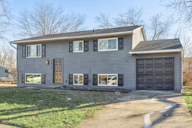 split foyer home featuring a garage and a front lawn