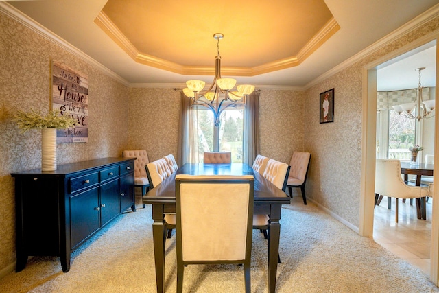 carpeted dining area with crown molding, a chandelier, and a raised ceiling