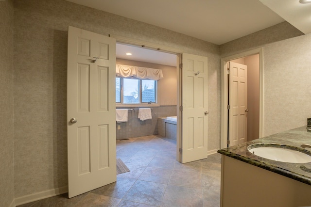 bathroom with vanity, tile walls, and a bathtub