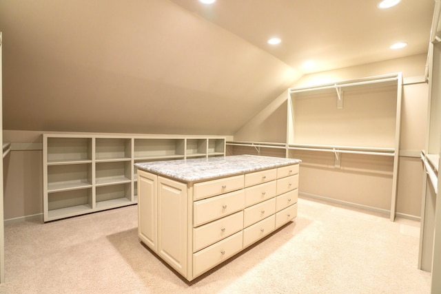 walk in closet with light colored carpet and lofted ceiling