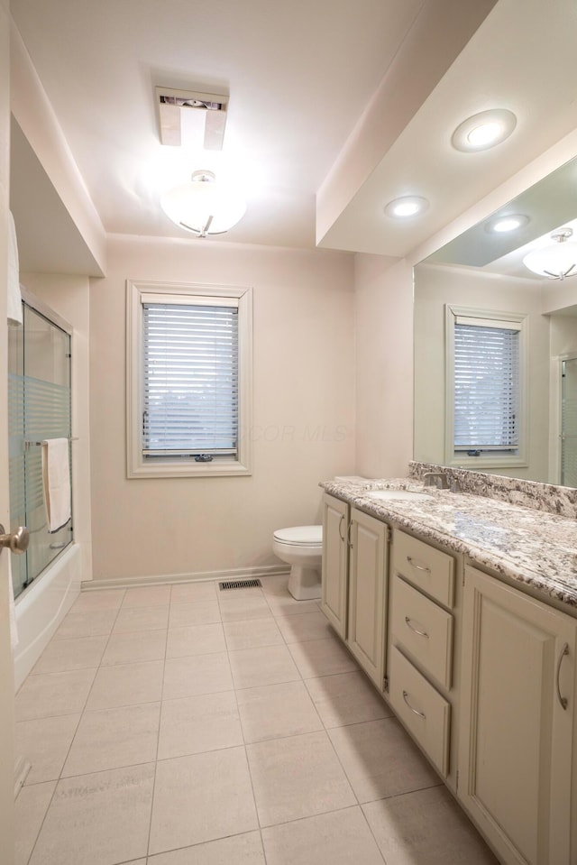 full bathroom with vanity, tile patterned flooring, enclosed tub / shower combo, and toilet