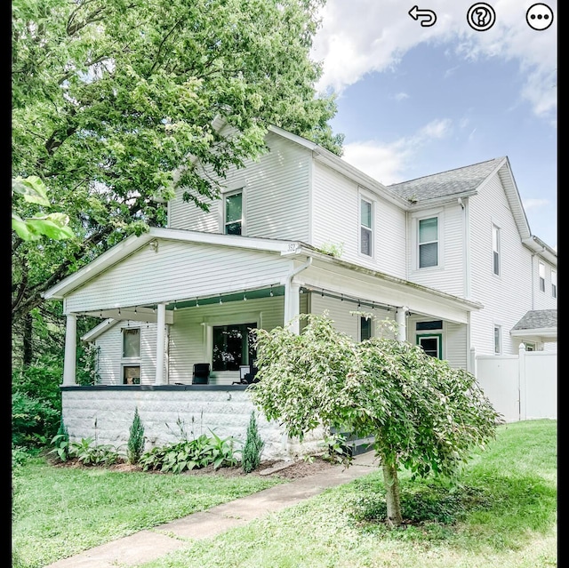 view of front of house with covered porch and a front lawn