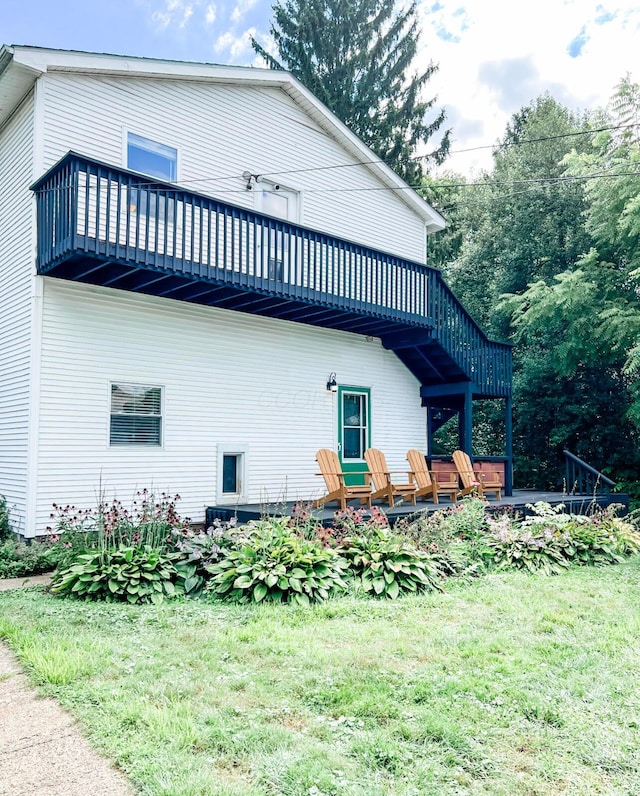 view of property exterior featuring a wooden deck and a yard