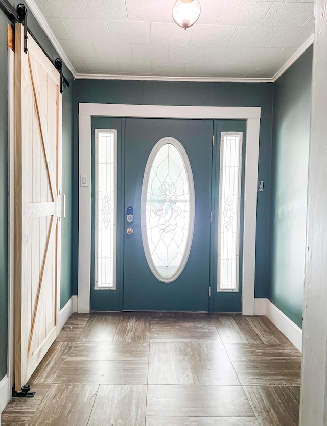 entrance foyer featuring crown molding, parquet flooring, plenty of natural light, and a barn door