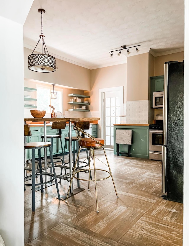 dining area with ornamental molding and rail lighting